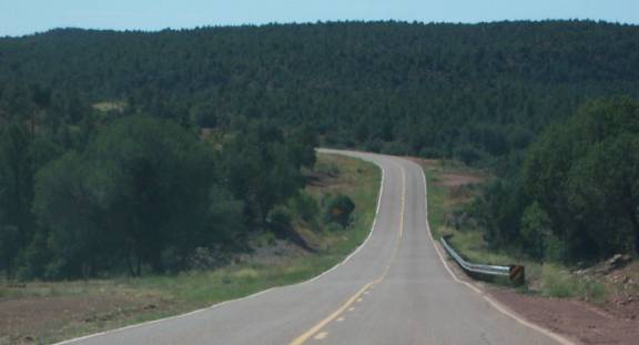 photo of a two lane road with a partial guardrail