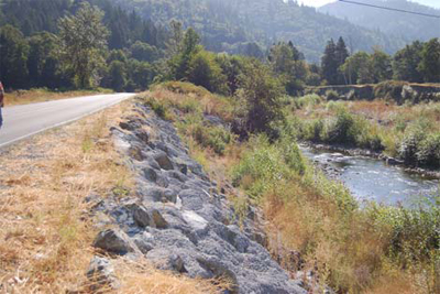 Newly constructed roadway and riprap along river