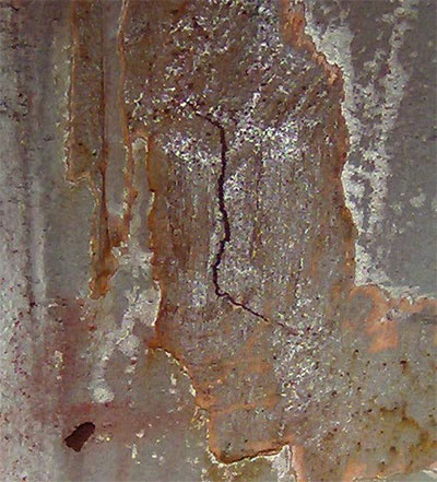 A crack measuring approximately 2 1/8 inches long by 1 1/4 inches deep in the side plate of the south tie of span 2 of the Sherman&ndash;Minton Bridge.