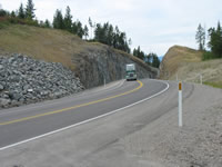 Large truck passing through large thru cut. Completion of Flowery Trail has opened a new corridor for industry.