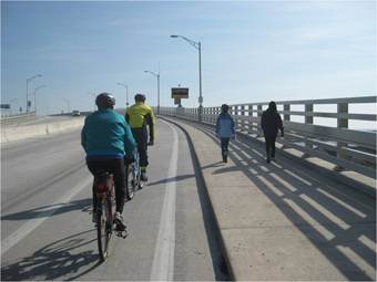 Photo of bicyclists on a bridge.