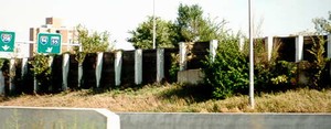 Photo of a noise barrier with posts close together and protruding from the surface of the panels to create a regular pattern