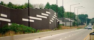 Photo showing a pattern on the noise barrier surface of large rectangles that contrast in color from panels