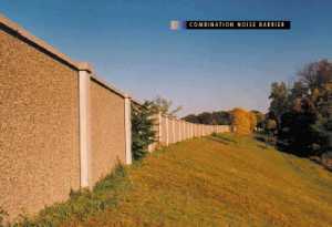 photo:  precast concrete noise barrier constructed on top of an earth berm, viewed from the side of adjacent development (photo is intended to illustrate a typical example of a combination-type noise barrier)