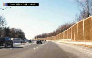 photo: precast concrete noise barrier, constructed immediately adjacent to the shoulder of a highway and protected by a concrete safety barrier (photo is intended to illustrate a typical example of a well-designed and well-constructed concrete noise barrier)
