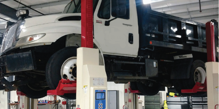 Image of a dump truck on hydraulic lifts inside a public works garage in the City of Hobart.