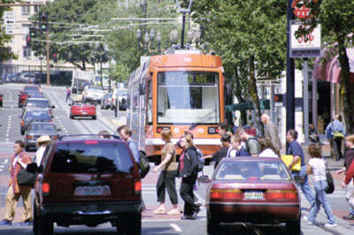 Pedestrians cross the street near streetcar stop.