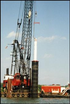 A 20 foot high, round dampener surrounds an underwater pile driving hammer to minimize noise from the impact of the hammer on the pile.