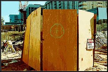 Stationary equipment is enclosed on all six sides with a temporary barrier of plywood found on the construction site. 