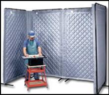 A construction worker at his workstation is shielded by a seven foot tall U-shaped barrier of plastic or vinyl material that can be easily relocated. 
