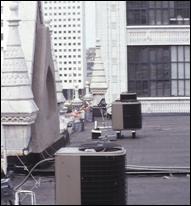 Several air ventilation units are located on the roof of the urban school (as seen from the roof).
