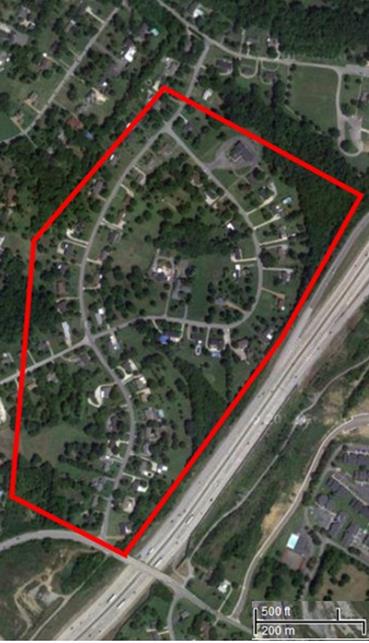 Study Area C: Ten-lane highway with medium-density houses curving away from the highway. The red polygon maps out the boundaries of the noise sesnsitive community.The road is in slight cut and there are groupings of houses on two curved residential streets with open area between them. 