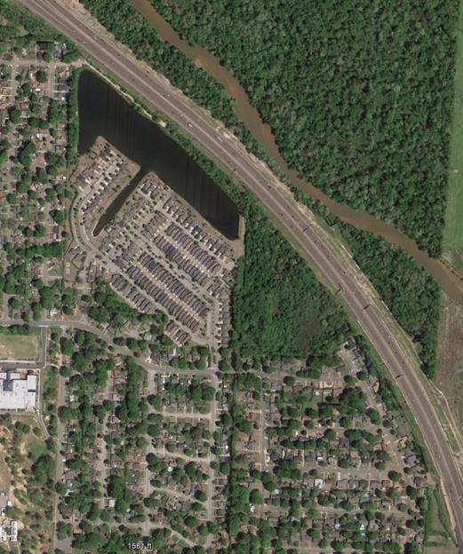 Aerial photo showing community for which a noise barrier was proposed by TDOT, Project TDOT-2. It shows single family and condos that are primaarily owner-occupied. The barrier was determined to be reasonable due to 94% of residents voted for the barrier. The road spans from the upper left side of the photo to the lower right corner. All residential, both single and multi-family are to the left of the roadway. 
