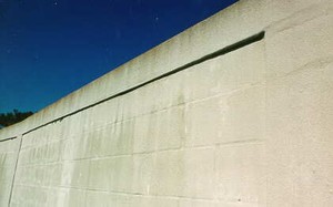 Photo of a masonry block noise barrier with a stucco surface finish