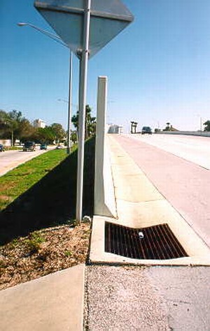 Photo showing a gutter in front of the noise barrier with a catch basin at the end of the barrier