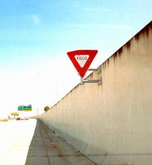 Photo of a noise barrier with a Yield sign mounted on the face of the barrier