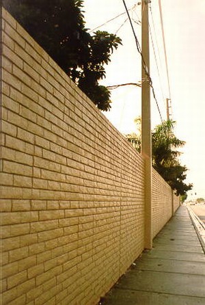 Photo of a pre-cast concrete noise barrier with a form-lined brick surface texture