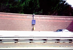 Photo of a noise barrier with safety call box mounted on the face of the barrier