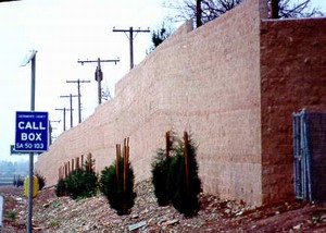 Photo showing a transition in noise barrier alignment from near the highway to closer to the residences