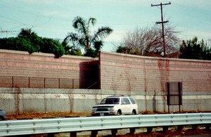 Photo of a noise barrier behind a cast-in-place retaining wall