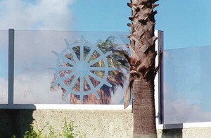 Photo of a transparent noise barrier with a surface stencil design of a ship's wheel