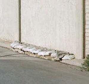Photo of a noise barrier that accomodates drainage under the bottom of the barrier
