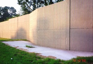 Photo of a noise barrier illustrating the need to accommodate underground utilities. The barrier alignment deflects around a catch basin.