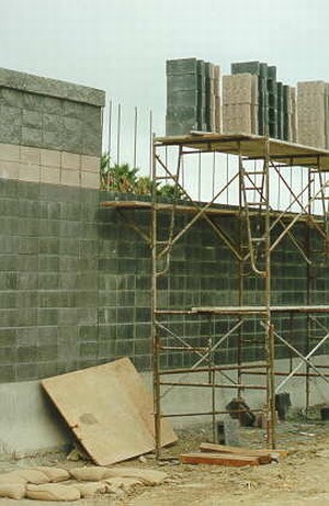 Photo showing a masonry block noise barrier under construction with scaffolding