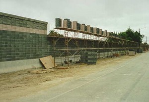 Photo showing a masonry block noise barrier under construction