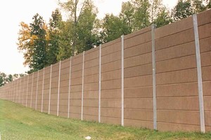 Photo of a noise barrier with stacked panel - each barrier segment consists of multiple stacked panels between two posts