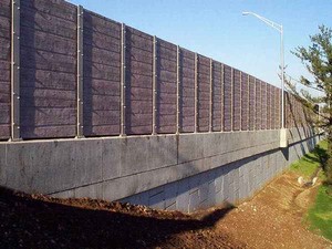 Photo of a noise barrier mounted on top of a retaining wall