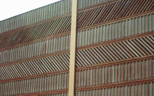 Photo of a wooden noise barrier with patterns on battens attached to the panels