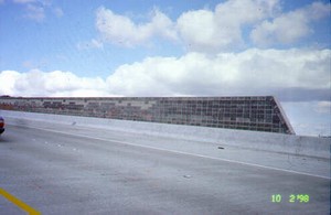 Photo of a concrete noise barrier on a bridge from the highway side