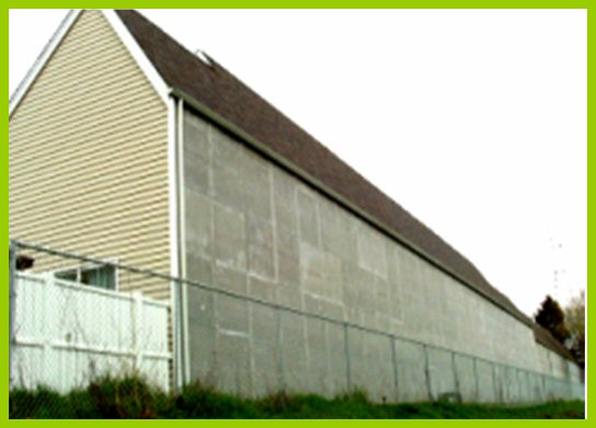 A residential structure is located near a roadway. To minimize noise levels entering the facade, no windows are located on the structure that face the roadway.
