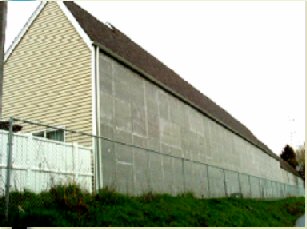 A house, with a courtyard located in the front yard, shields receivers from noise. 