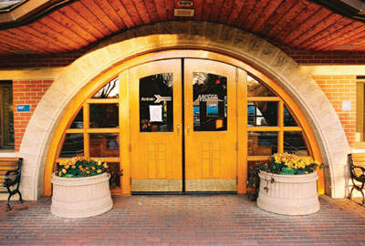 Photo of doors in an archway with flower planters.