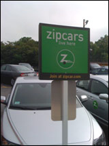 Photo of a Zipcar sign in a parking lot