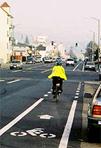 The second image is a person riding a bike in a bicycle lane in San Francisco, California. 