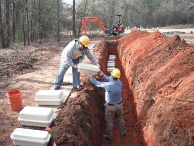 Photo of construction worketrs burying caskets.