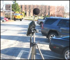 A noise analysis using a sound level meter in a school parking lot to establish pre-construction background noise levels.