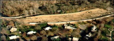 An aerial photo of a highway construction site that has been graded. Since noise barriers were part of the highway project, they were built first to shield nearby residences from the majority of construction activities.