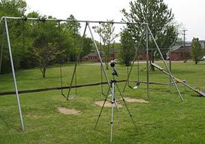 A sound level meter measuring sound level near a common play area within a neighborhood.