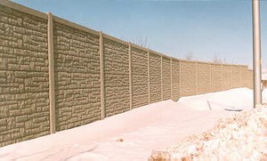 Photo of a noise barrier near the residences with snow drifted against the barrier