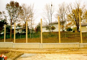 Photo of a noise barrier mounted on top of a retaining wall under construction