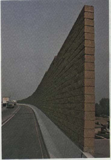 photo of a highway with a tall, brick wall