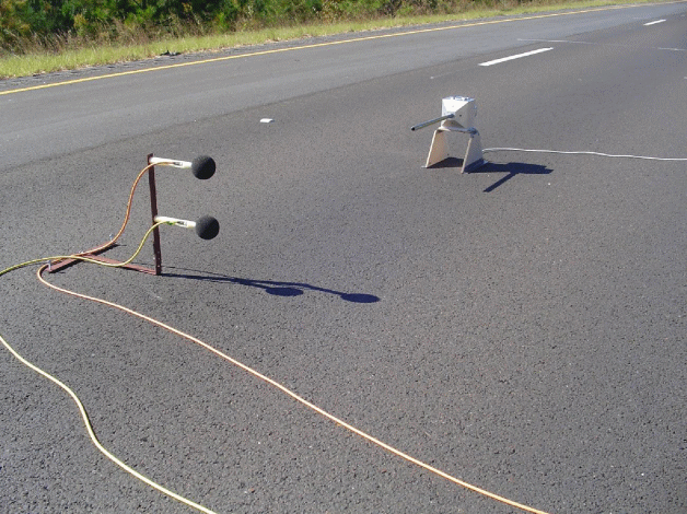 This figure contains 2 photographs on the EFR instrumentation.  The first illustrates two microphones a set distance away at two different heights above the travel lane and a point source in the form of a compression driver tube.   The second illustrates the tone generator and electronic equipment used to record that data. 