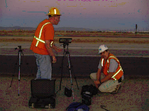 This figure contains 3 photographs of noise measurement set-ups that are in conformance with the set-up required for REMEL level measurements. The first contain two individuals setting up a radar gun to determine the speed of the traffic.  The second is of an individual setting up a video camera to tape the traffic as measurements are being taken.  The third is of two noise meter as different distances from the road, while a heavy truck passes by. 