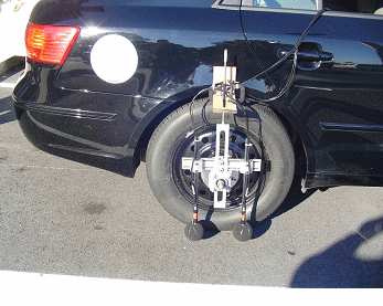 This figure contains 3 photographs on the OBSI noise measure system.  The first illustrates the wheel mounting system and dual microphones. The second is the recording device and the third shows an individual with a laptop in which the data it be saved to. 