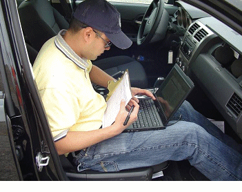 This figure contains 3 photographs on the OBSI noise measure system.  The first illustrates the wheel mounting system and dual microphones. The second is the recording device and the third shows an individual with a laptop in which the data it be saved to. 