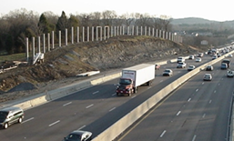 Title: Roadway in cut - Description: Bird's eye view of a roadway in cut with a noise barrier being constructed near the right-of-way.